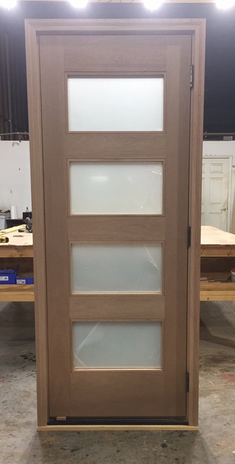 A wooden door with frosted glass panels is sitting on top of a wooden table.