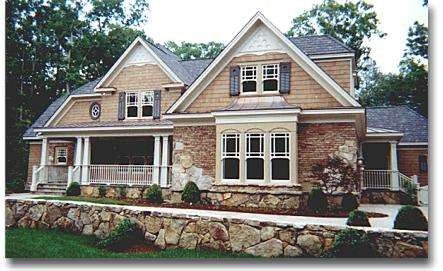 A large house with a stone wall in front of it