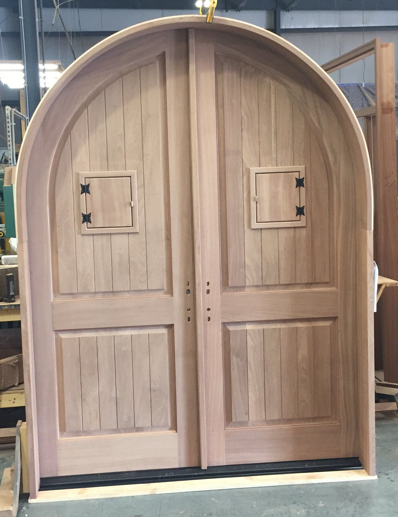 Gorgeous and massive this archtop double entry door features operating speakeasy doors. in the top panels.  Shown here in unfinished Mahogany.