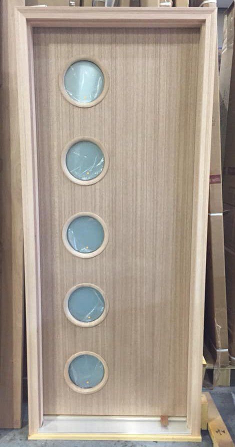 A wooden door with four round windows on it.