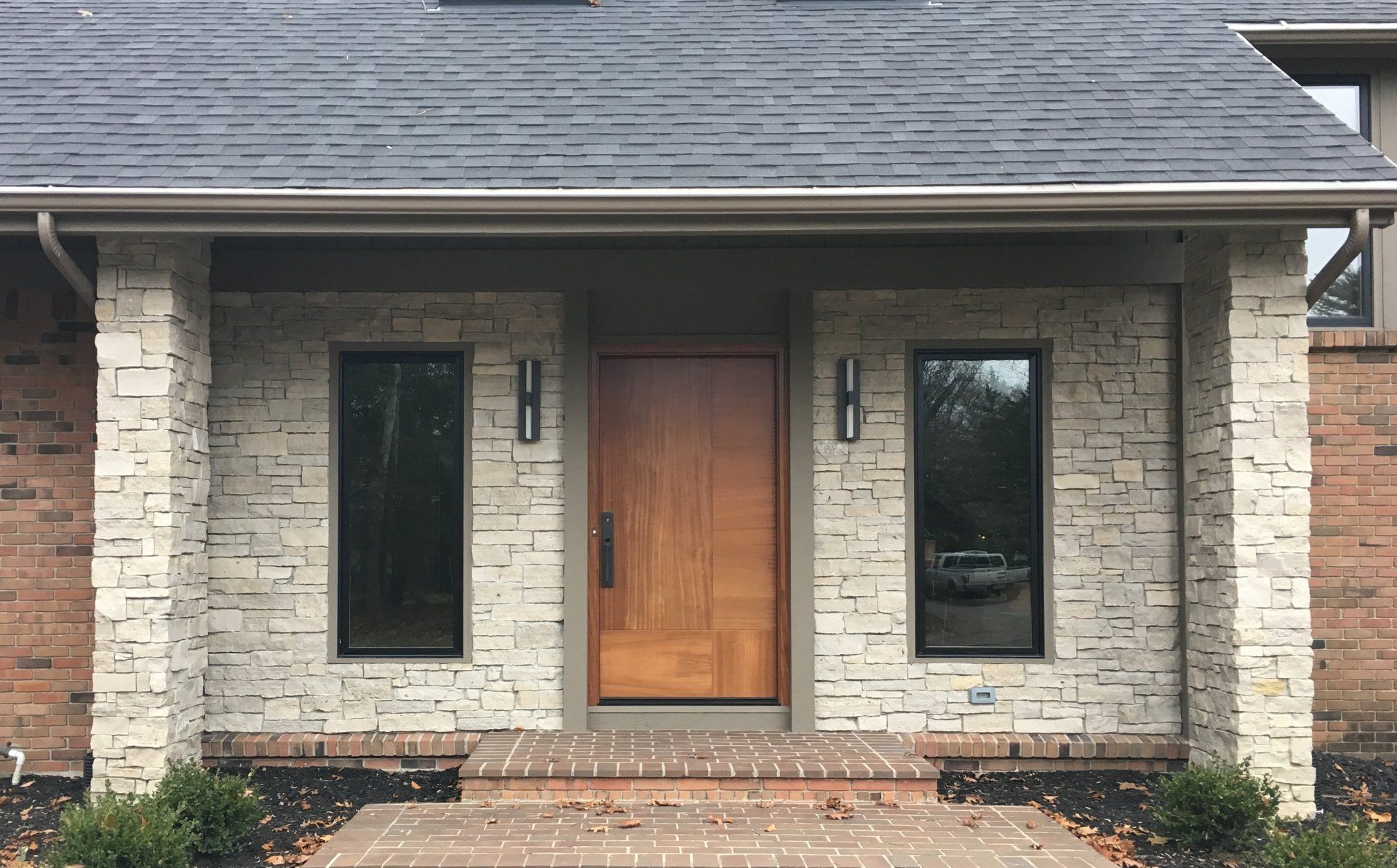 A brick house with a wooden door and two windows