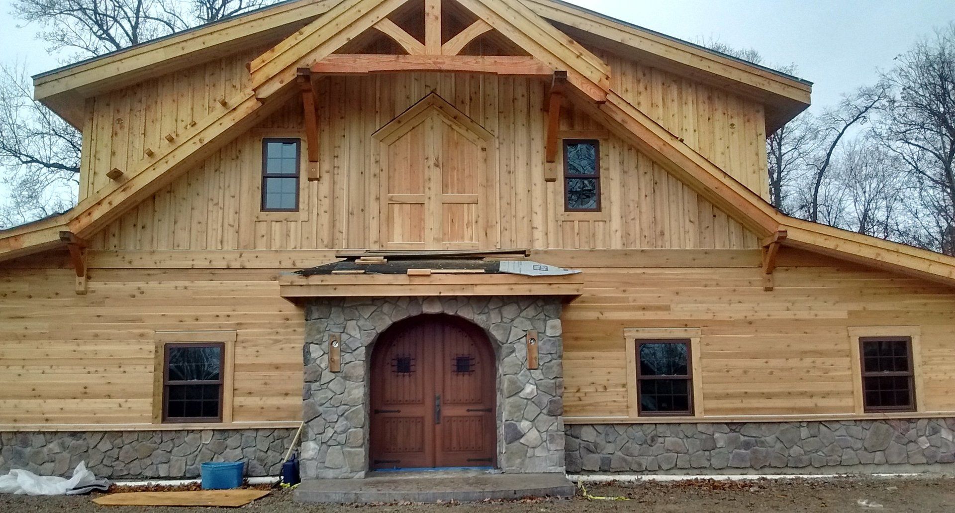 A large wooden building with a stone wall and a wooden door.