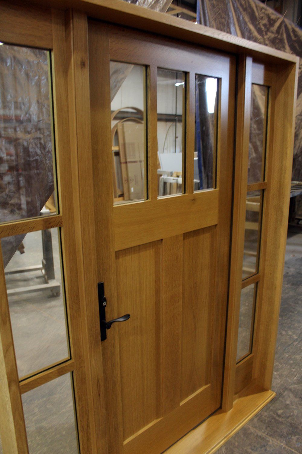 Rift sawn white oak Shaker style entry door with sidelites angle view shows square panel profile.