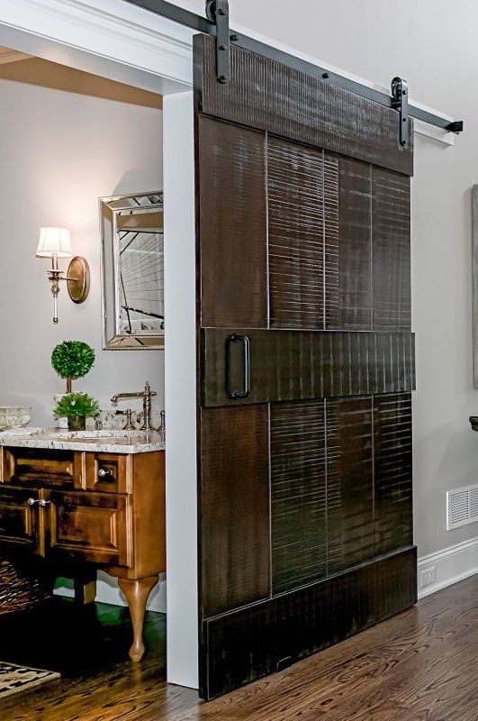A bathroom with a sliding barn door and a sink.