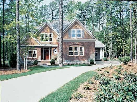 A house in the middle of a forest with a driveway leading to it