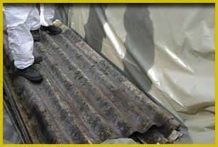 For asbestos removal in Bristol and Bath call Matthews Asbestos Removal asbestos remover standing on asbestos