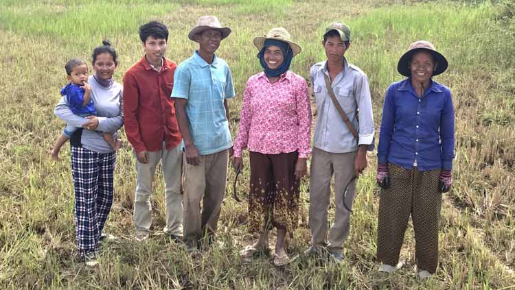 A group of people are standing in a field.