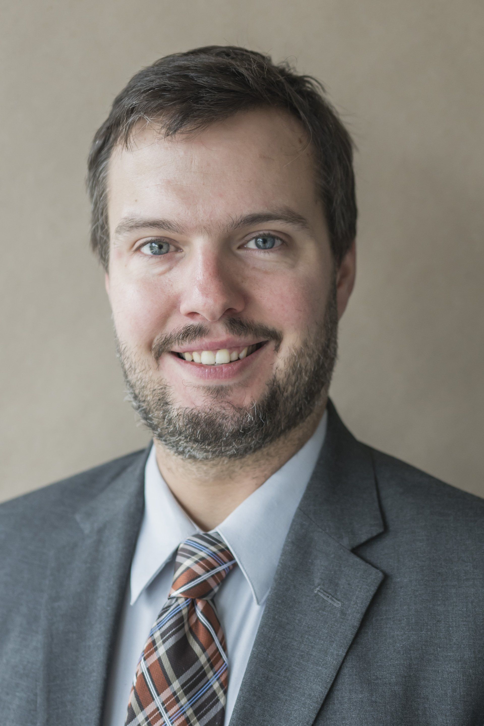 A man in a suit and tie is smiling for the camera.