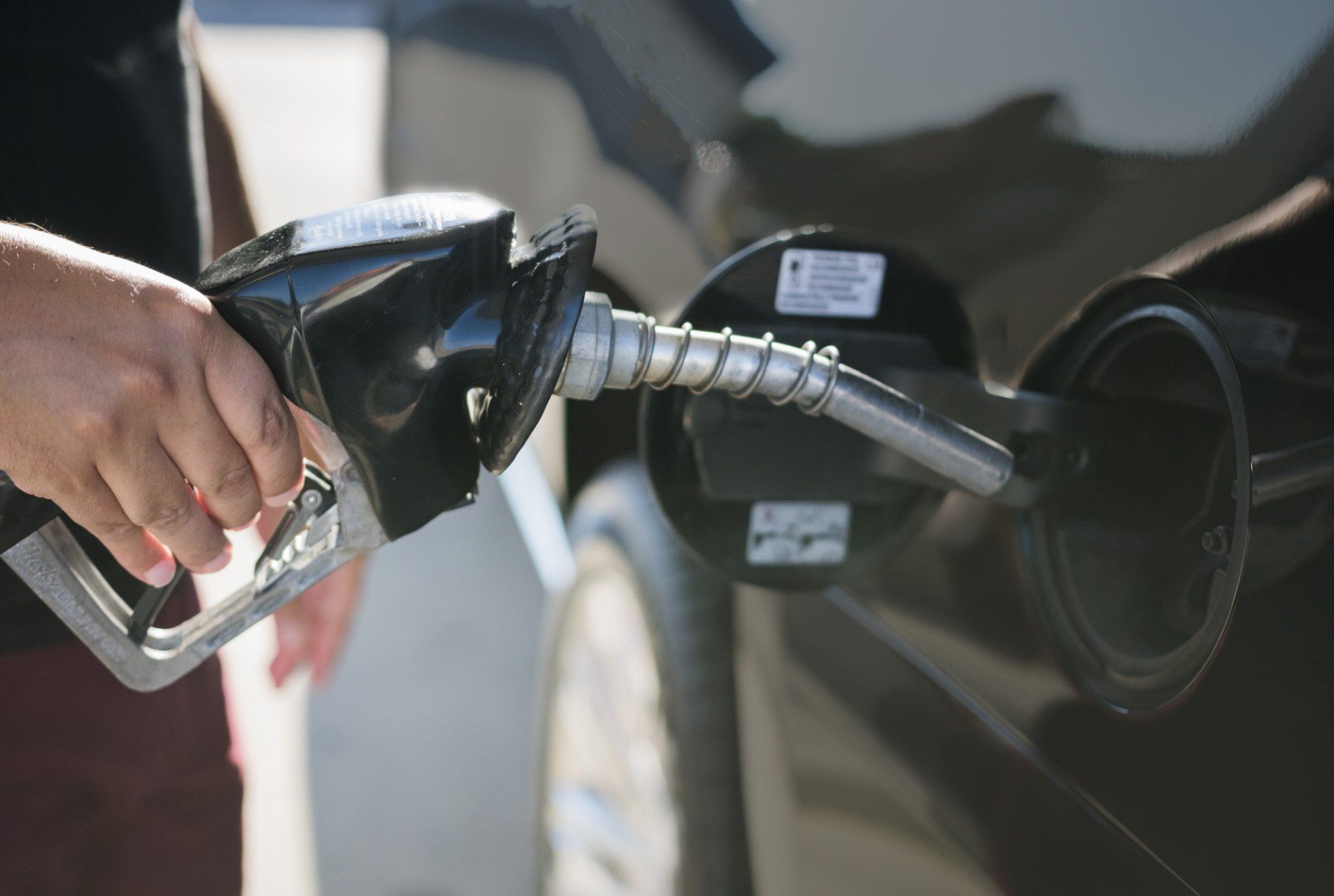 A person is pumping gas into a car at a gas station.