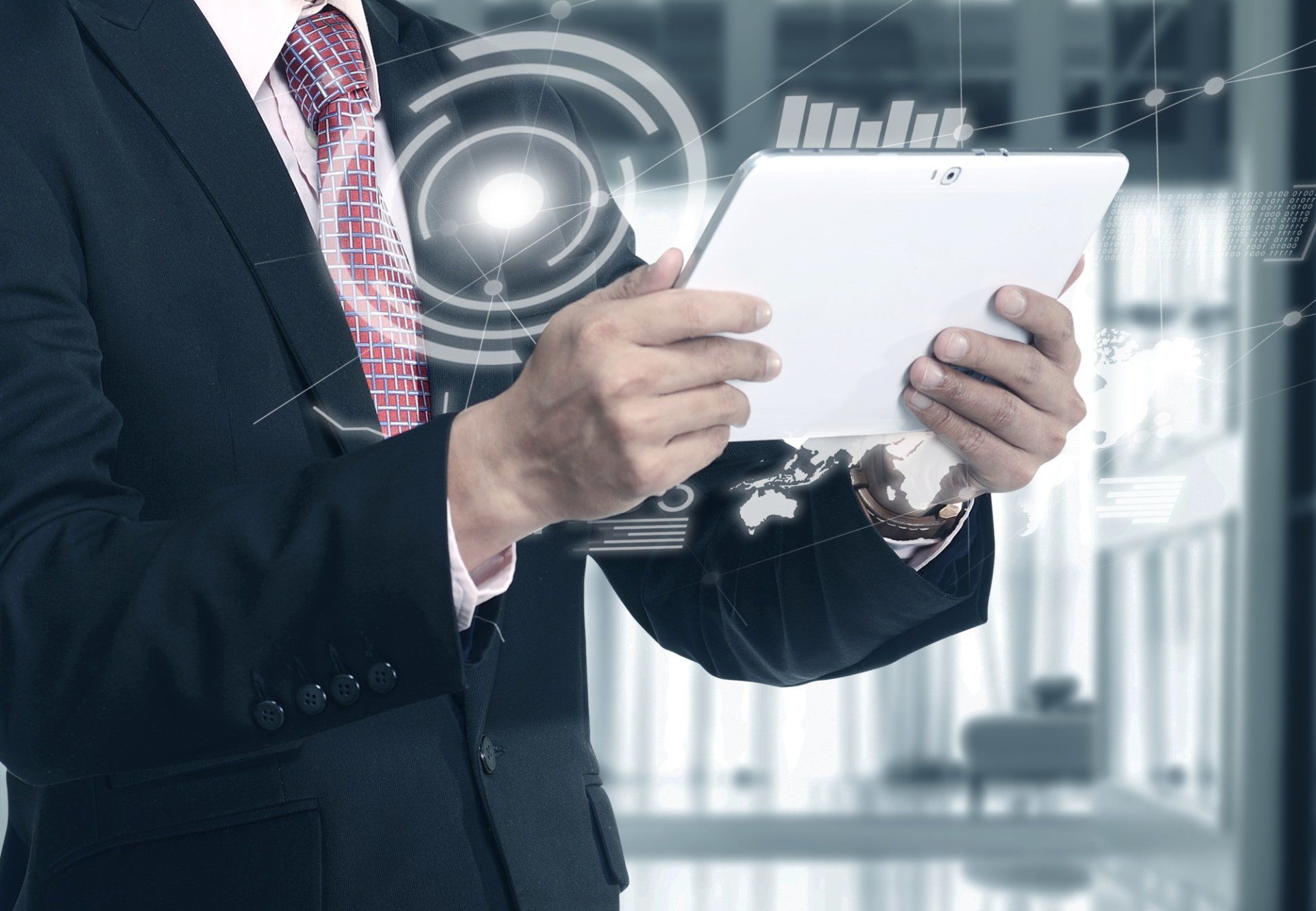 A man in a suit and tie is holding a tablet in his hands.