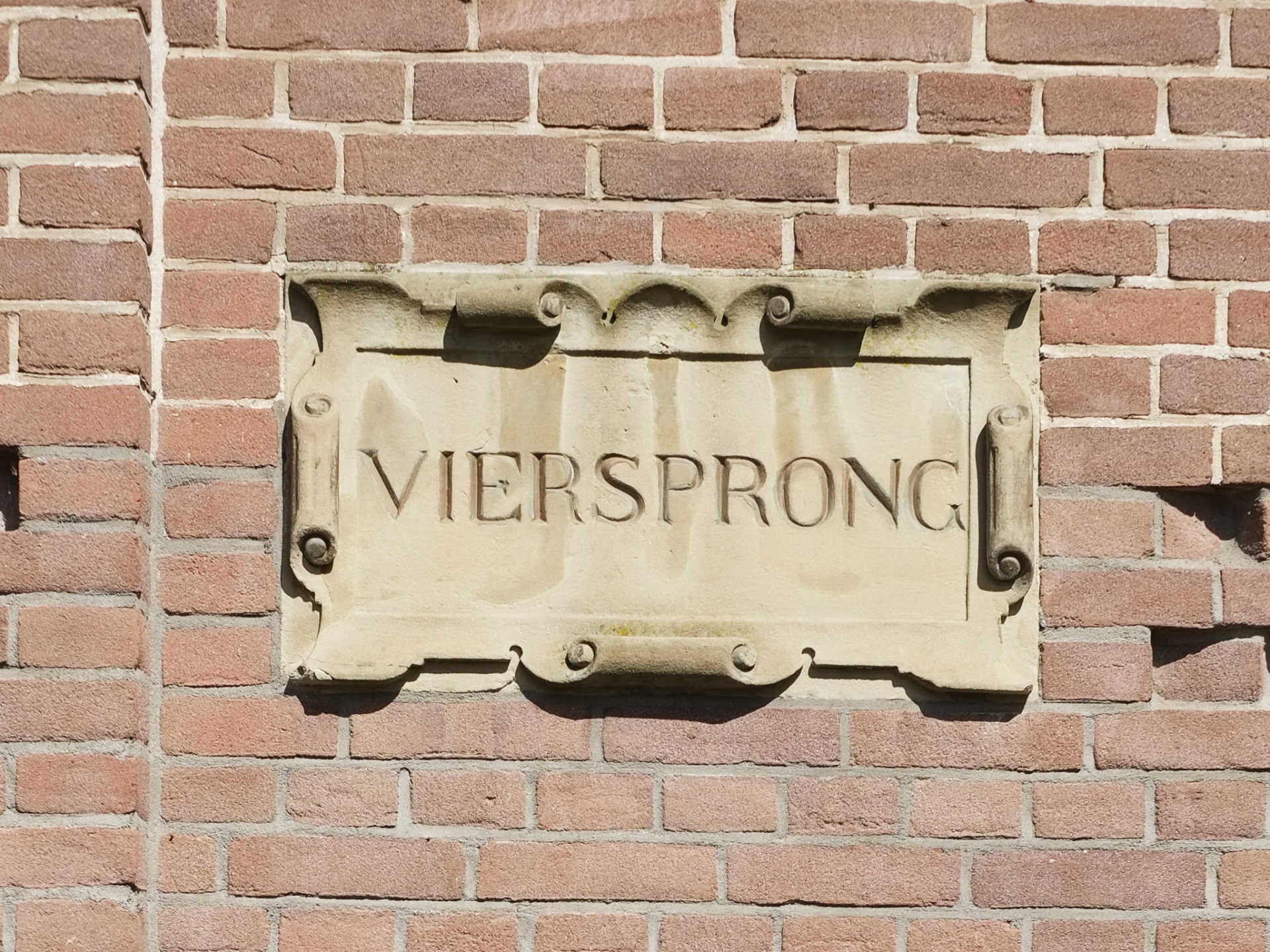 Een bordje op een bakstenen muur zegt viersprong