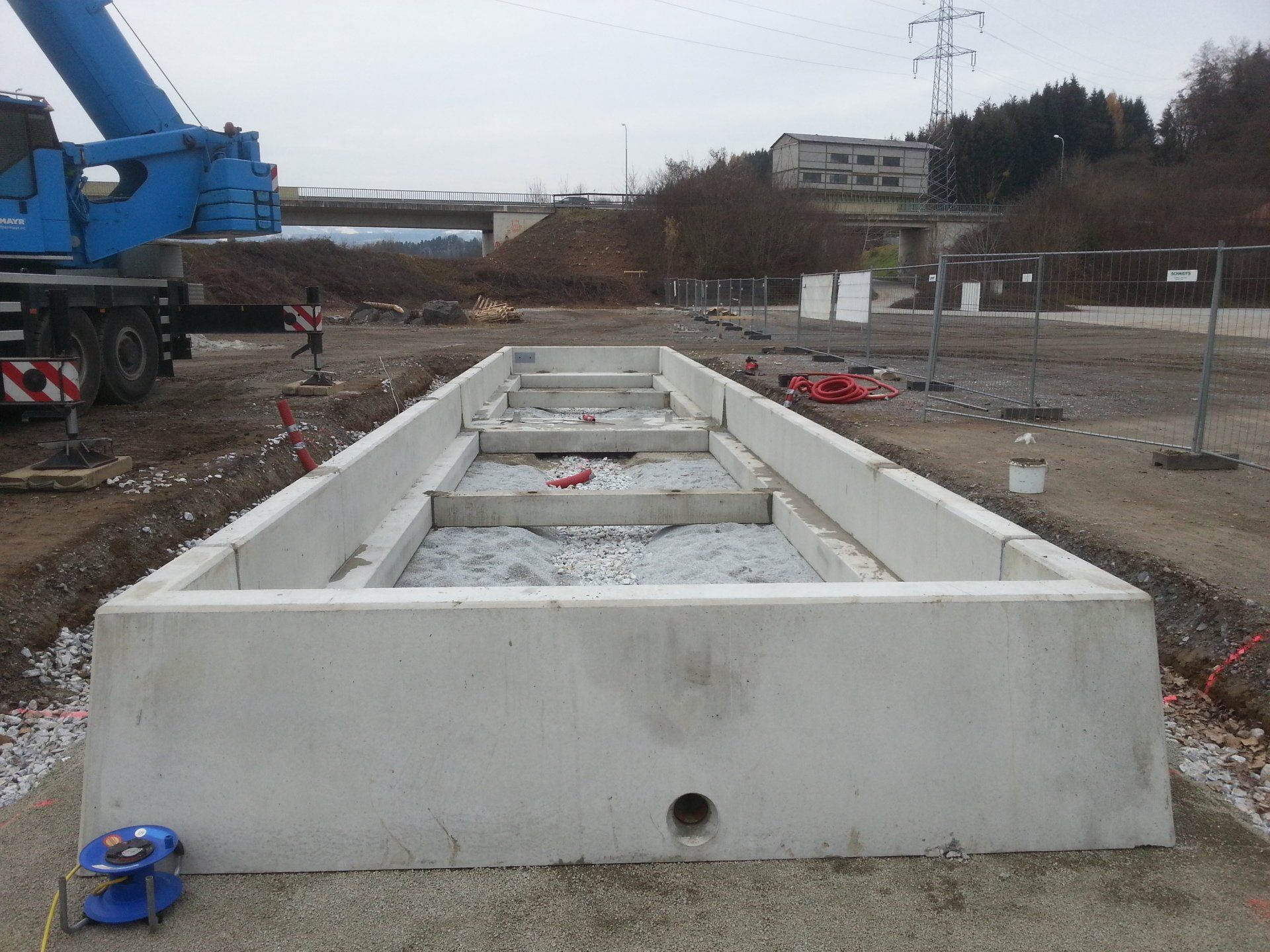 Eine Baustelle mit einem blauen Kran im Hintergrund