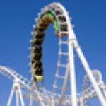 Bright yellow roller coaster train looping through a white track against a blue sky