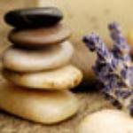 Stacked spa stones with a lavender sprig on a beige background
