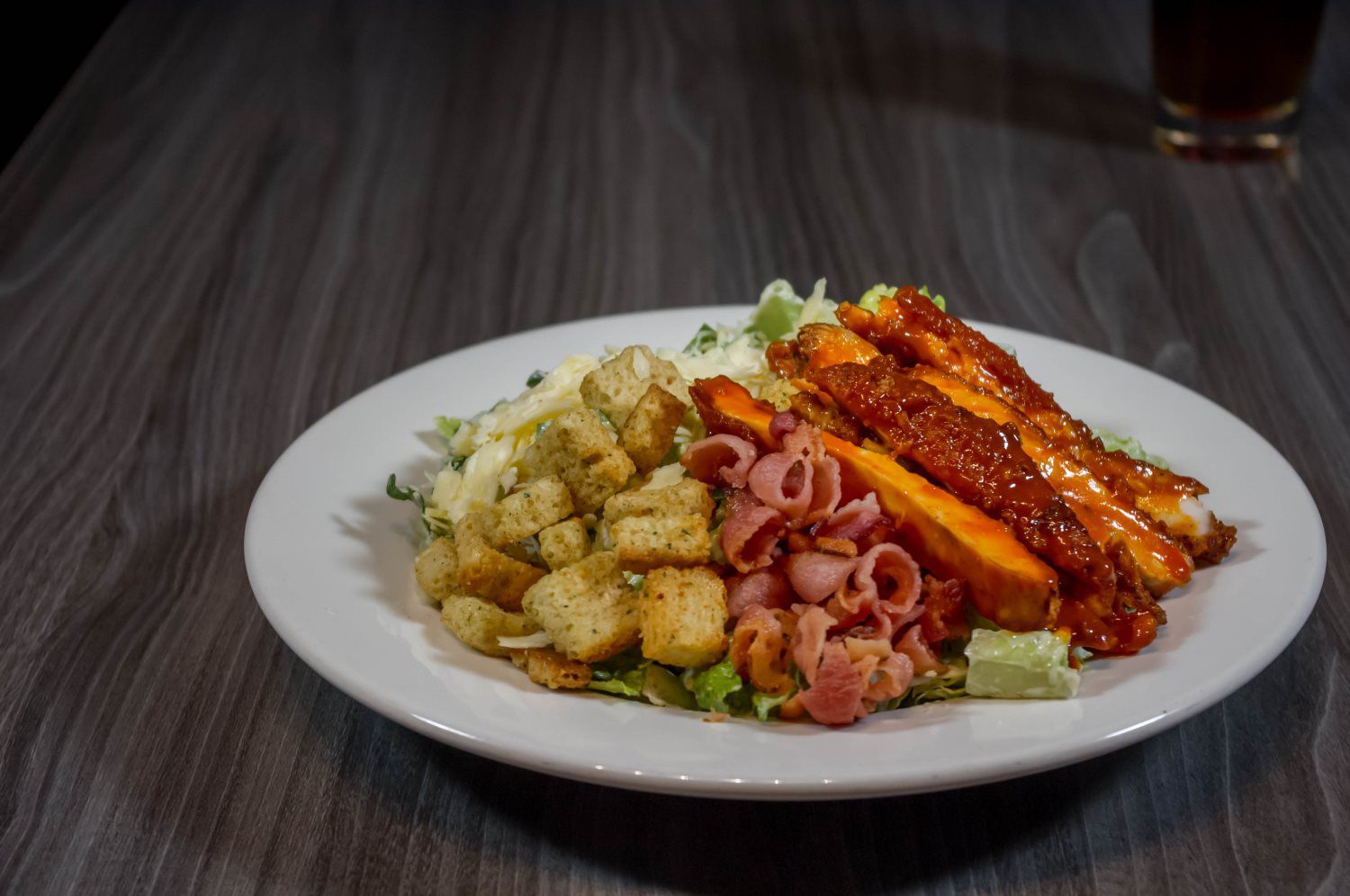 Plated pasta dish with breaded chicken, red sauce, and vegetables on a dark table