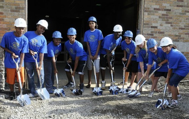 A group of children at Boys & Girls Club of Lenawee wearing hard hats and holding shovels