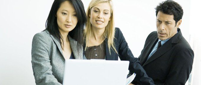 Office workers around a laptop