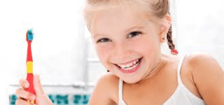 Una bambina che ride con uno spazzolino in mano