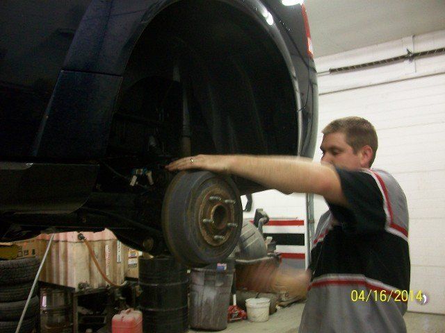 Man After Removing Car Wheel — Villas, NJ — John's Auto Body