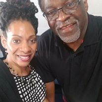 A man and a woman are posing for a picture together and smiling.