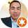 Portrait of a man in a white shirt with an orange star badge on the corner