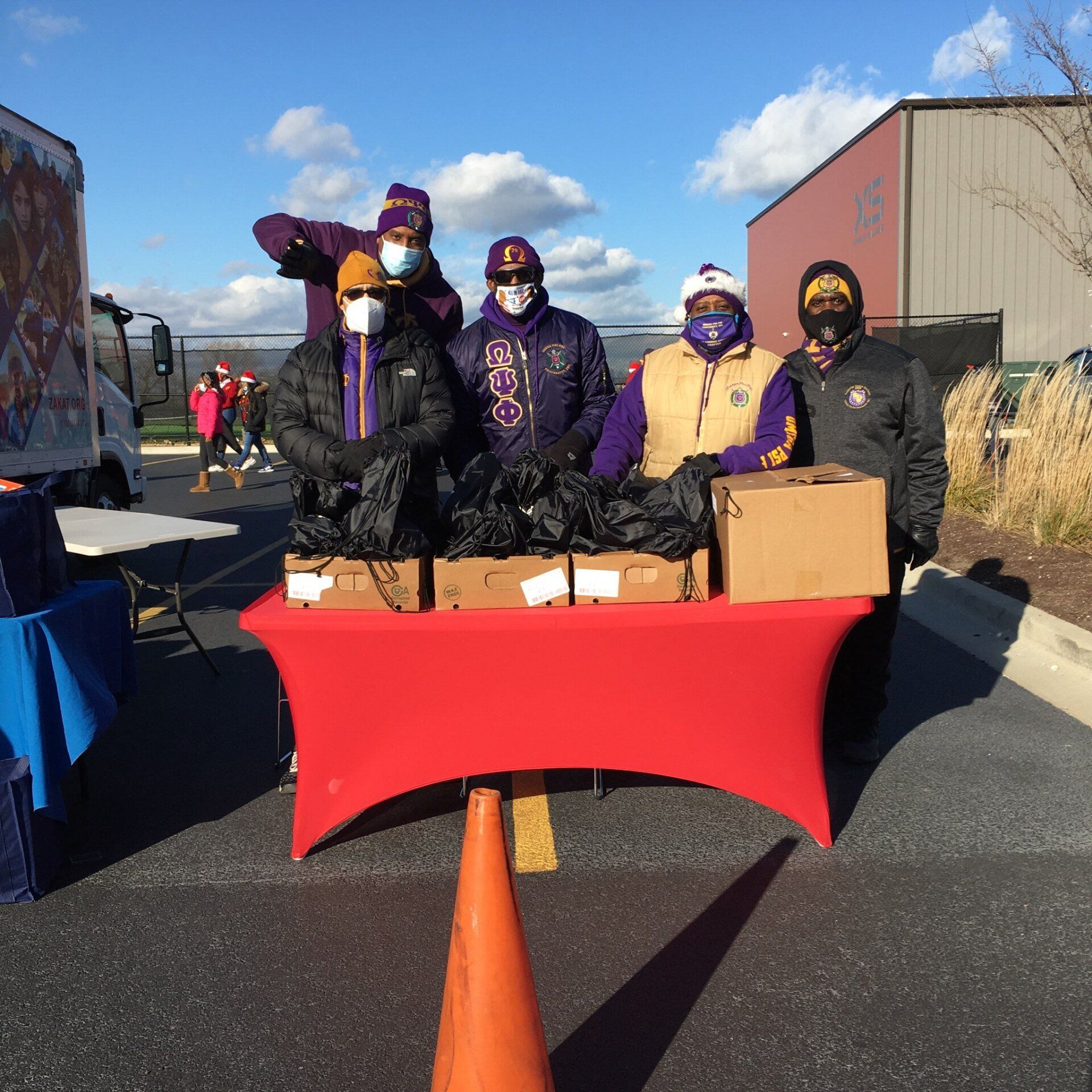 A group of people standing around a table with boxes on it