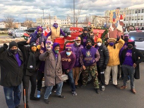 A group of people wearing masks are posing for a picture