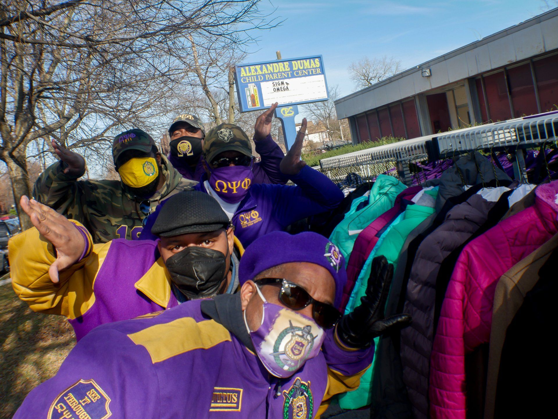 A group of men wearing face masks are posing for a picture.