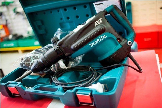 Un martello demolitore elettrico Makita AVT nella sua custodia color verde acqua.