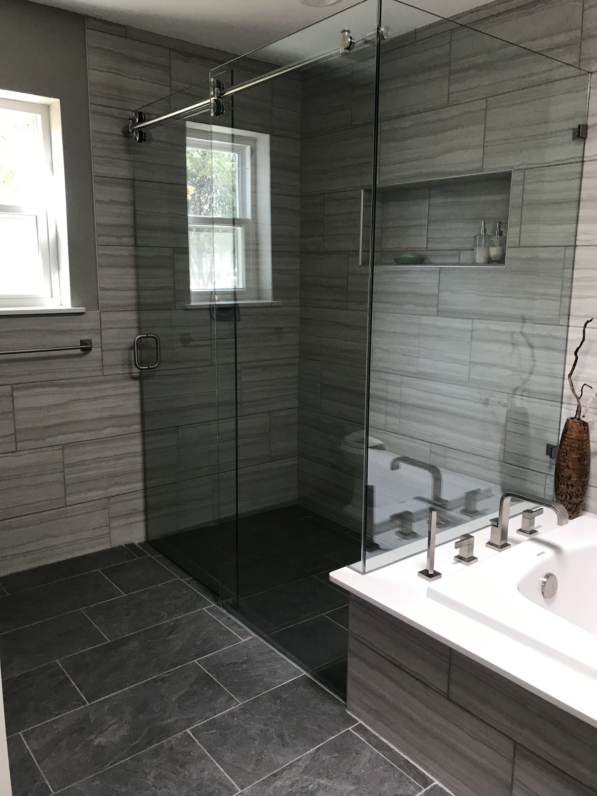 A bathroom with a walk in shower and a bathtub.
