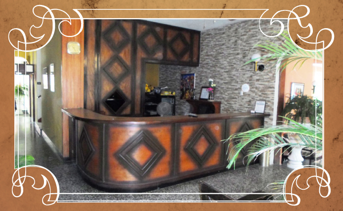 Mostrador de recepción de hotel con decoración en madera y piedra, enmarcado por detalles decorativos 