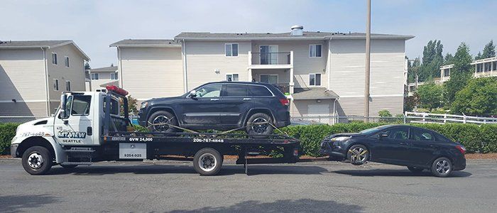 Roadside Assistance — Two Black Cars on Tow Truck in Seattle, WA Roadside Assistance — Two Black Cars on Tow Truck in Seattle, WA