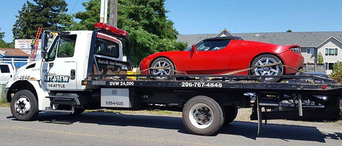 Lock Out Services — Modern Red Car on Tow Truck in Seattle, WA Lock Out Services — Modern Red Car on Tow Truck in Seattle, WA