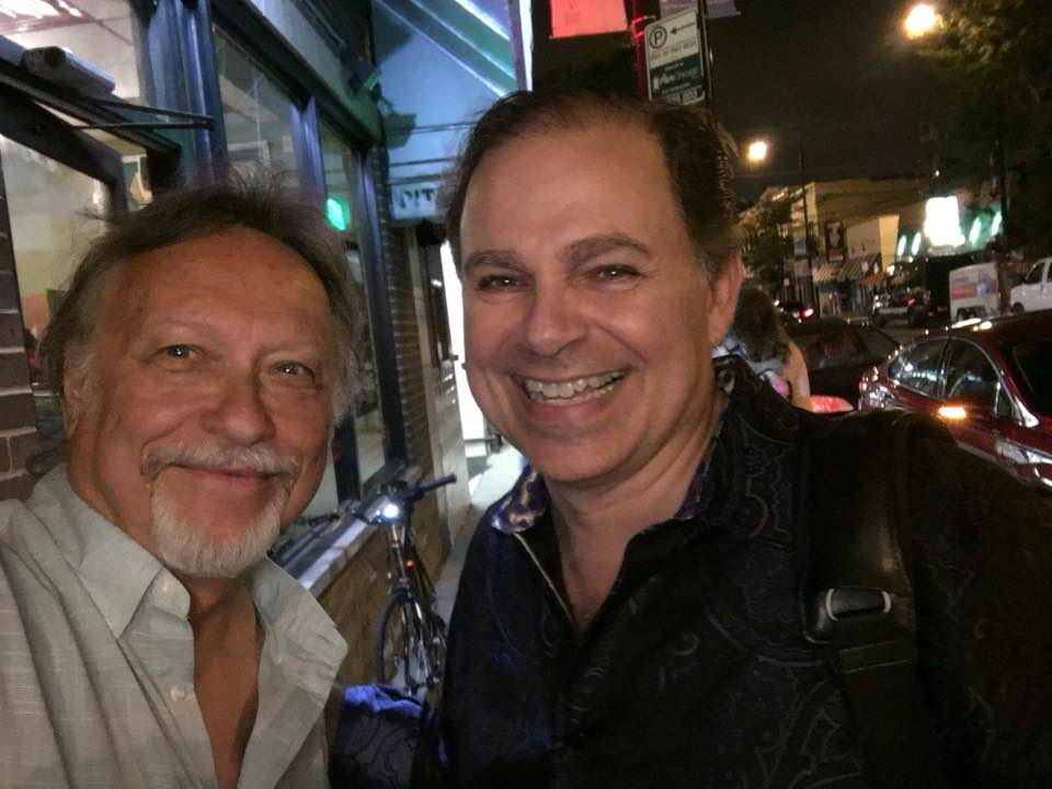 2 men standing outside posing for picture