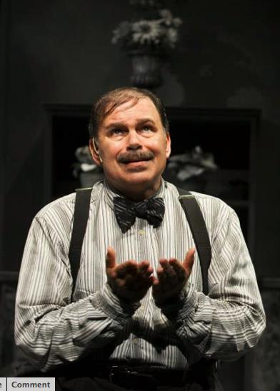 Man with mustache wearing striped shirt with bow tie and suspenders