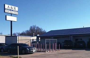A & R Auto & Truck building with sign; cars parked in front, blue sky.