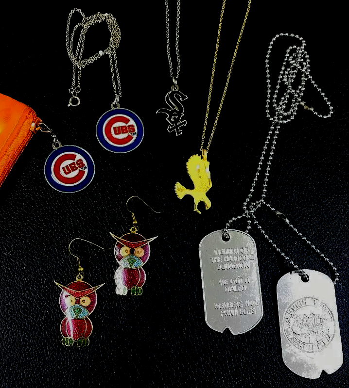 A bunch of necklaces and earrings with one that says cubs on it