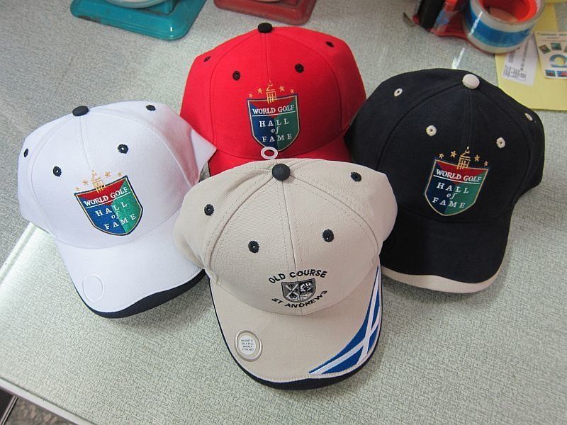 Four hats are sitting on a table and one of them has a shield on it