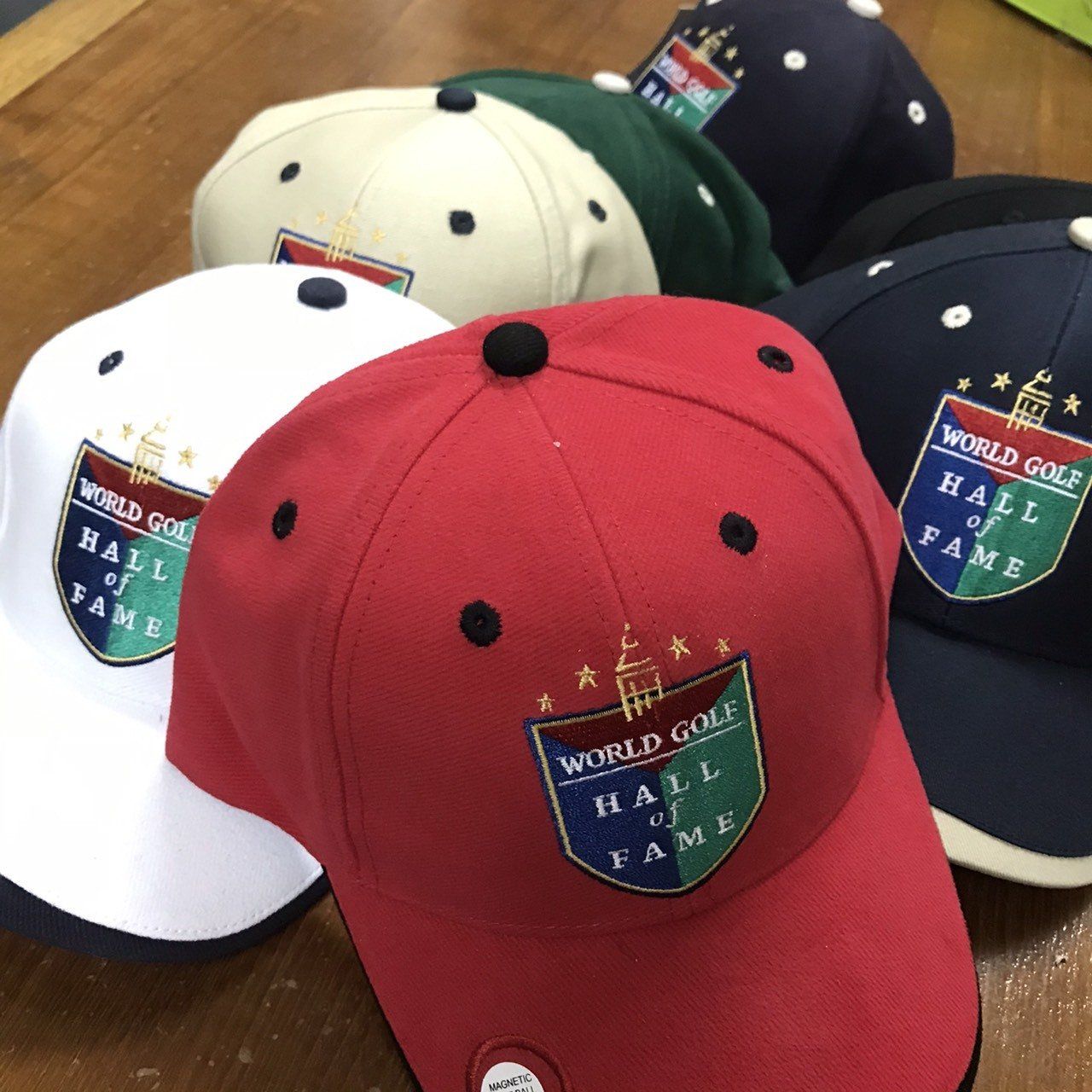A group of world golf hall of fame hats on a table