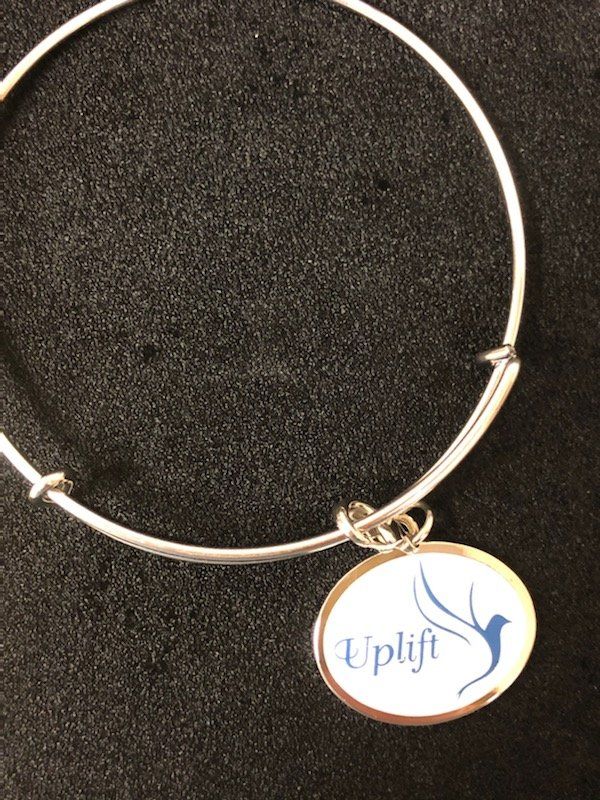 A bracelet with a charm that says uplift on it