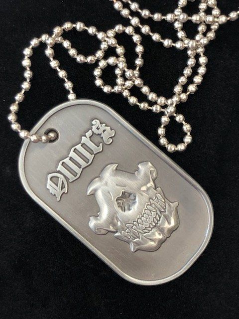 A dog tag on a chain that says dmrs
