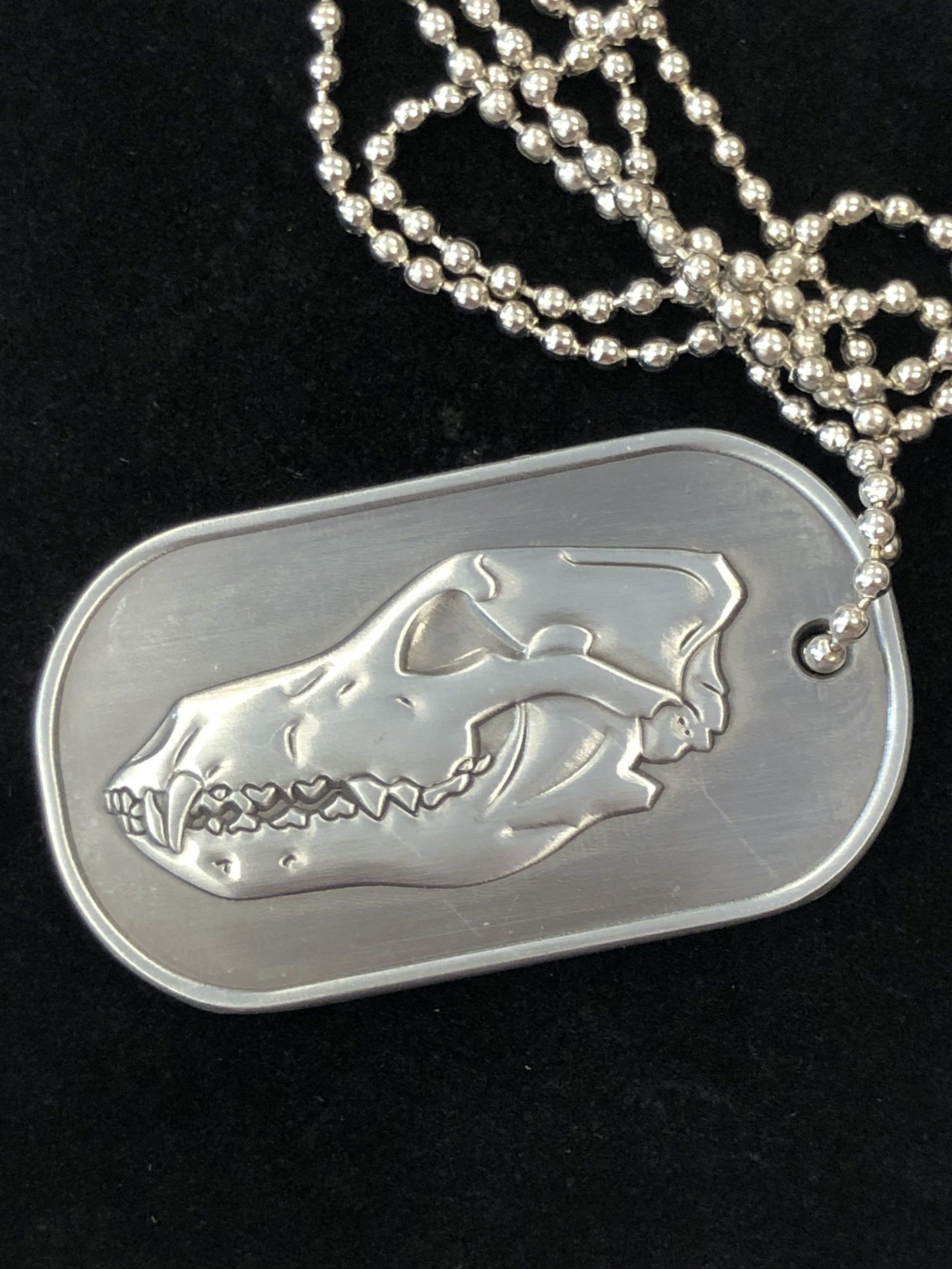 A dog tag with a picture of a dog 's skull on it