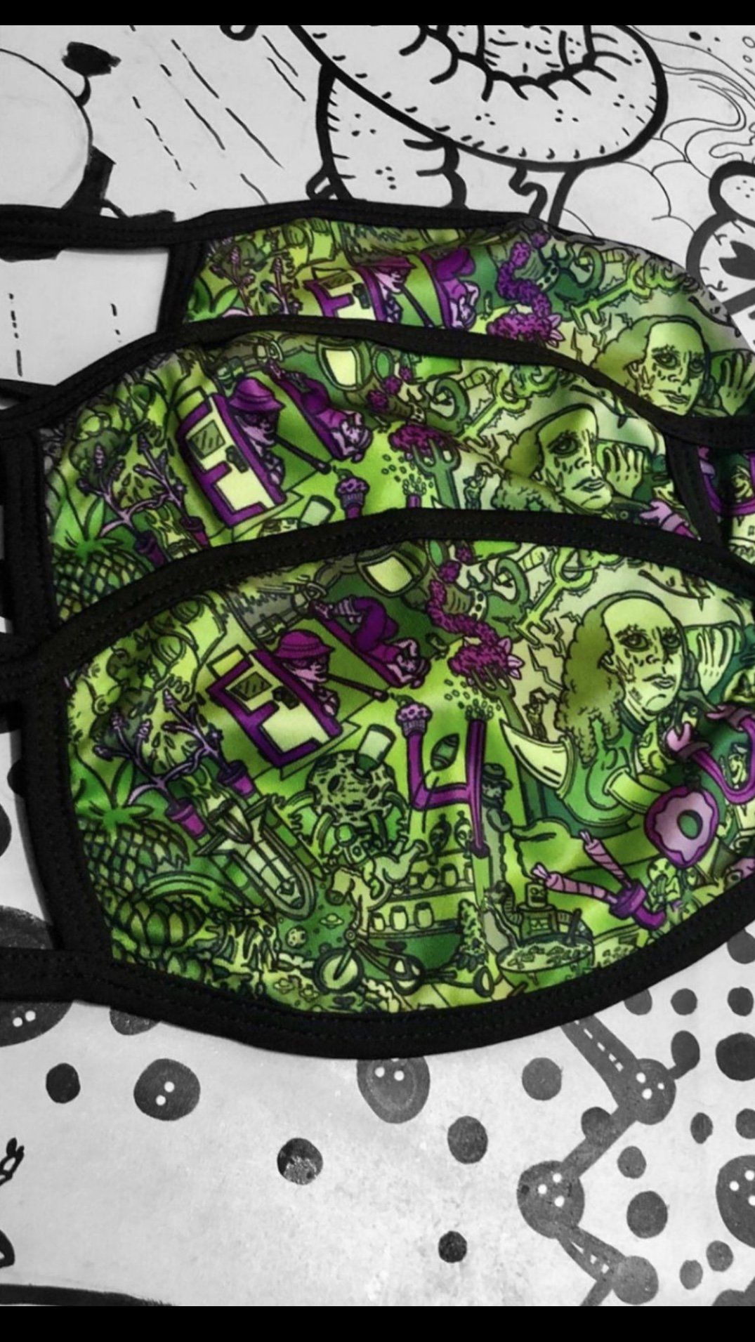 A green and purple face mask is sitting on a table.