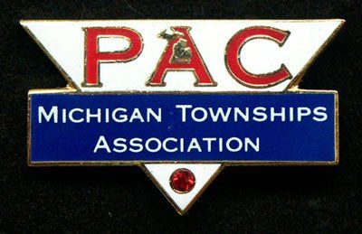 A pac michigan townships association pin on a black background