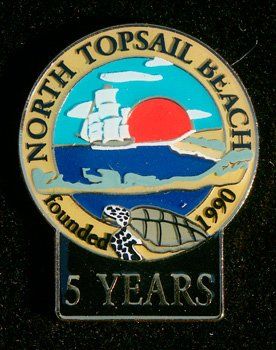 A pin that says north topsail beach founded in 1990