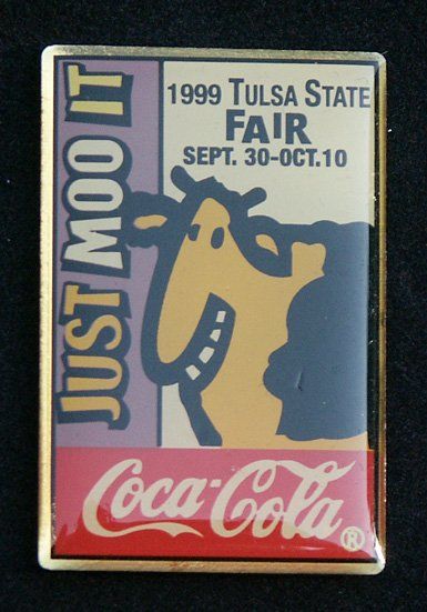 A coca cola pin from the 1999 tulsa state fair