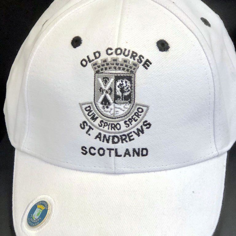 A white hat that says old course st andrews scotland
