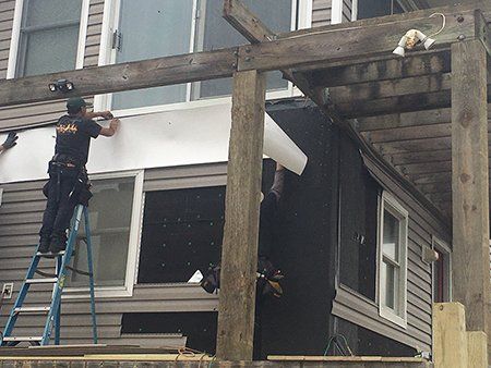 Worker hanging siding