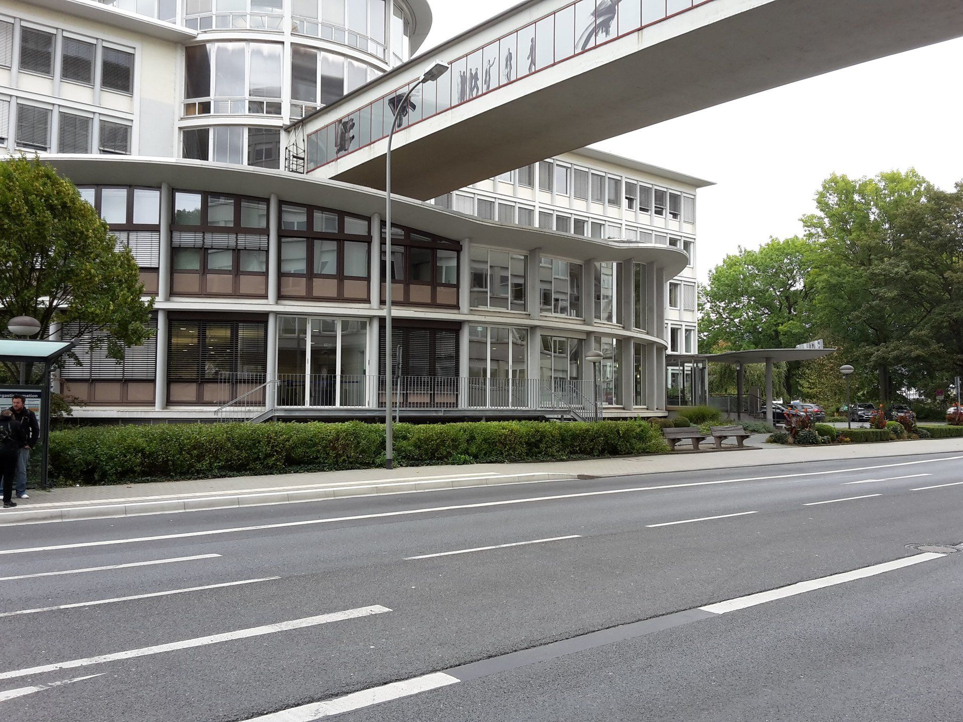 Ein mehrstöckiges, modernes Bürogebäude mit Glasfassade, das über einen hohen, über 