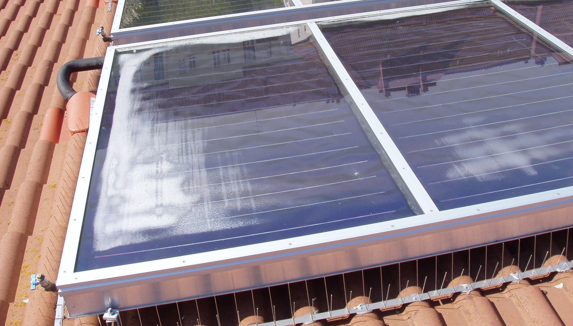Ein Solarpanel sitzt auf einem Ziegeldach